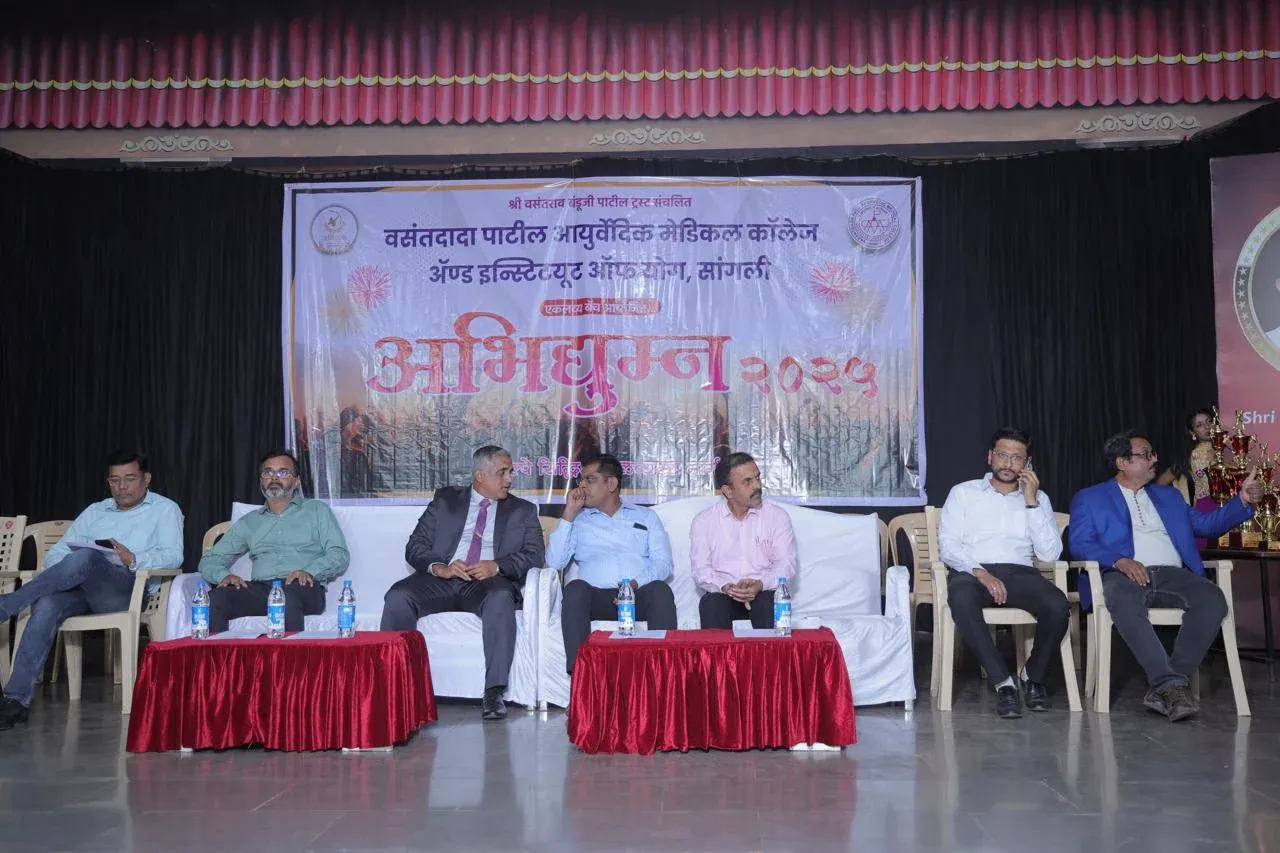 A seated panel of guests on stage at a school event