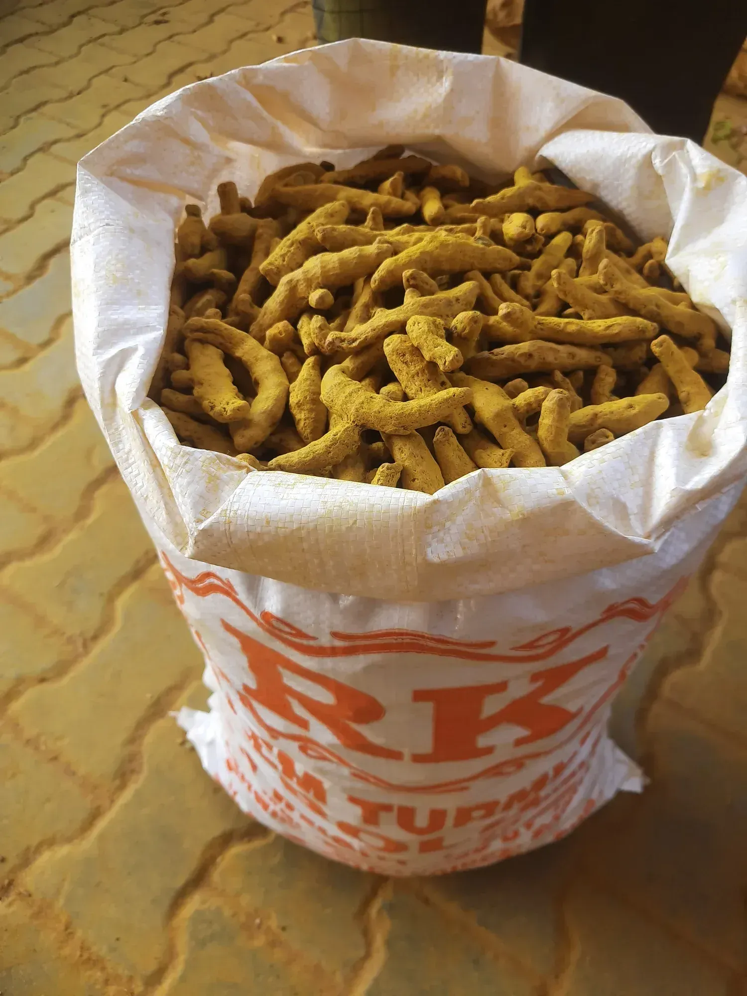 An open printed export sack filled with bright dried turmeric fingers