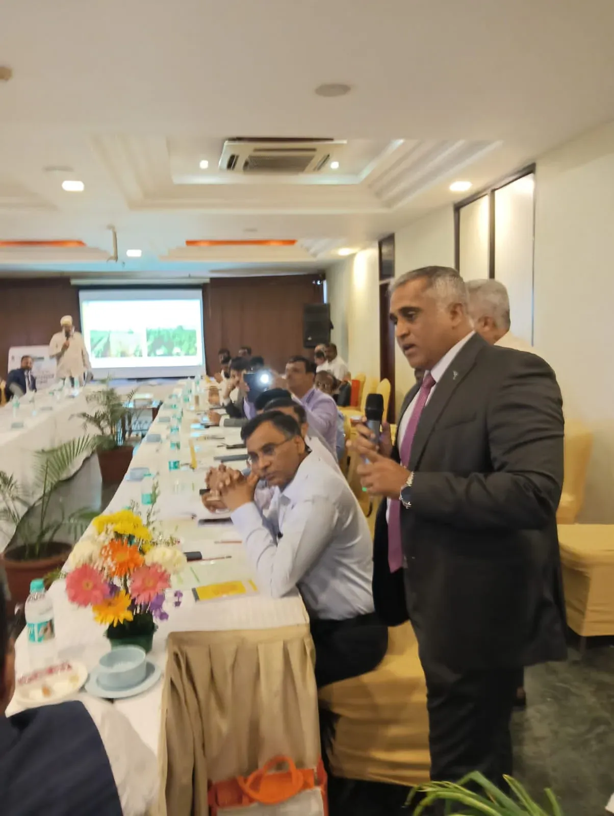 Captain Mahesh Khochare presenting to officials seated around a conference table