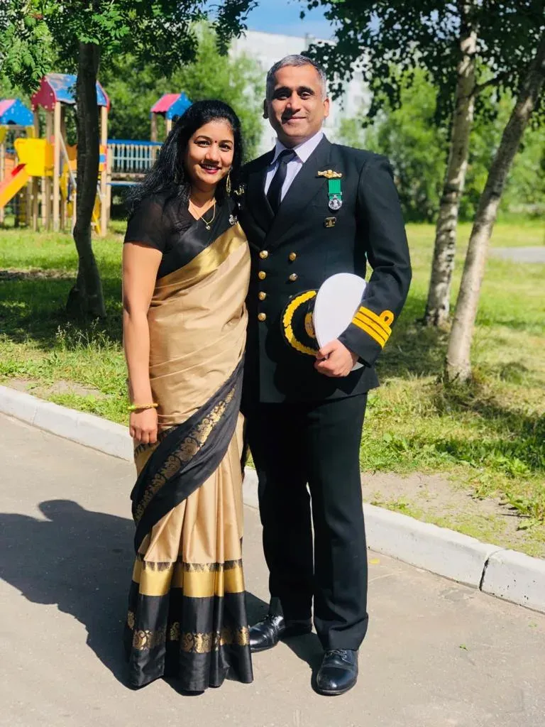 Captain Khochare in dress blues beside Mrs. Khochare in a gold and black saree