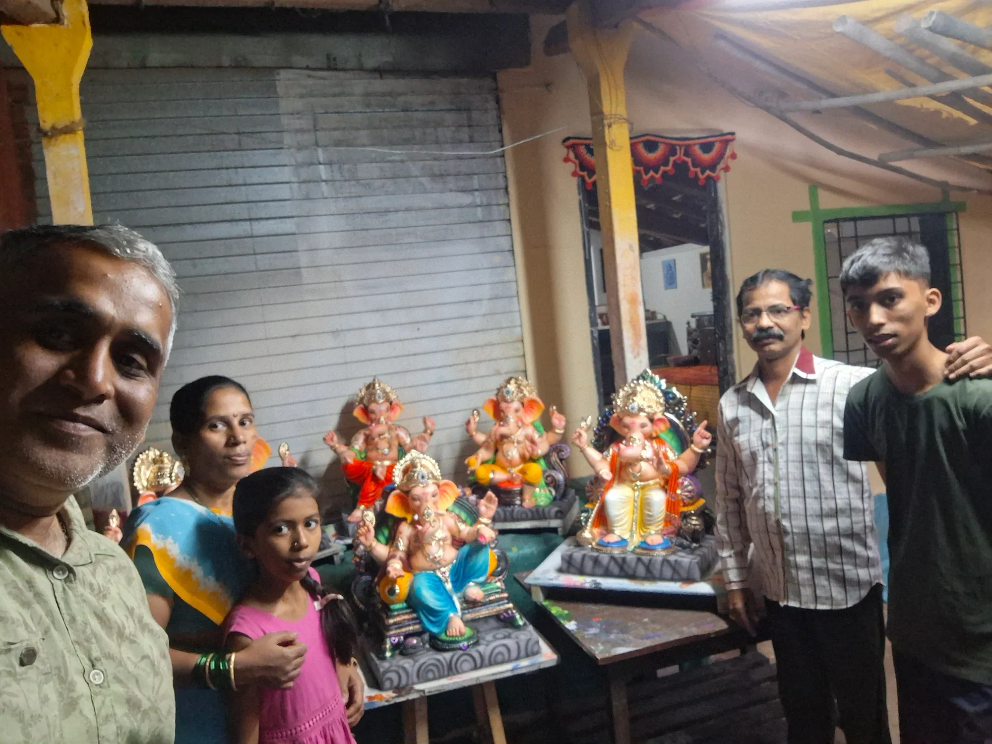 The family with local artisans beside finished idols at Kankavli
