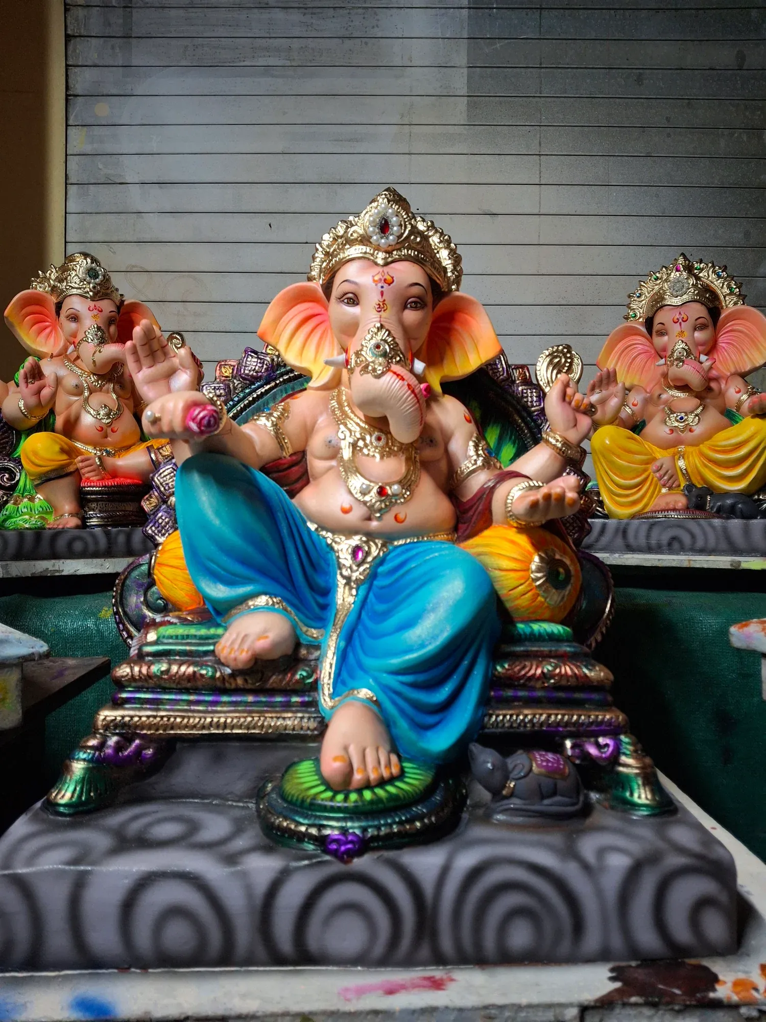 A row of painted Ganesh idols lined up in a workshop