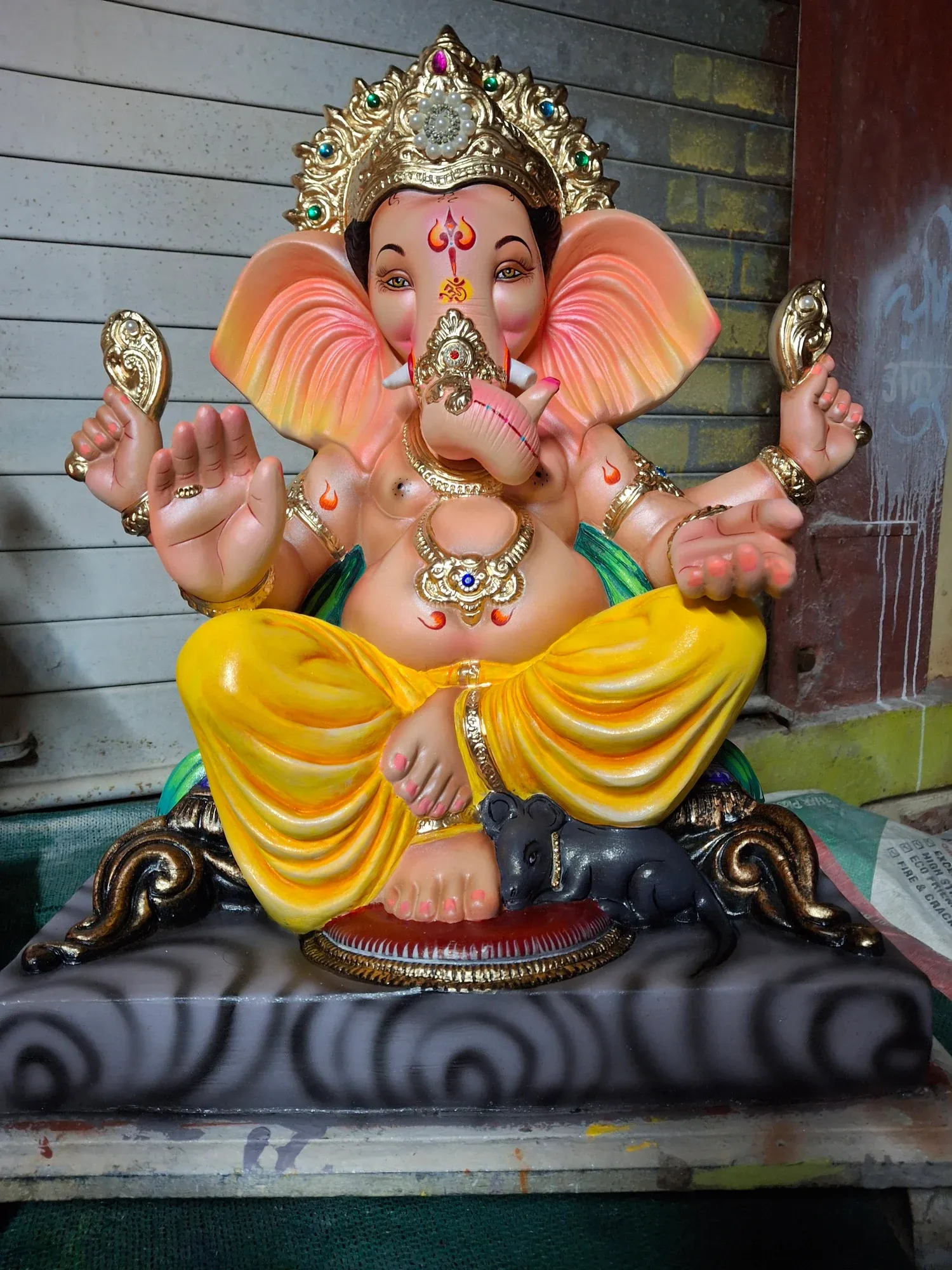 Painted Ganesh idols standing in the artisan workshop